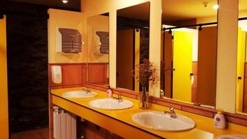 A bathroom with three sinks, a mirror, and a towel rack.