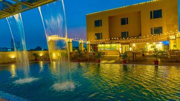 Una piscina al aire libre, sillones reclinables de piscina