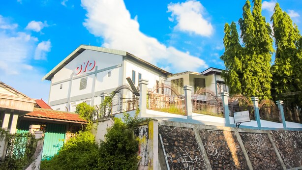 A building with a sign that reads "HOTEL" and a stone wall in the foreground. - OYO 1905 Davonsa  Homestay Syariah (Pekanbaru)