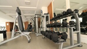 A gym with exercise equipment, including dumbbells and a treadmill. - Apatel The Mansion Tower Capilano (Jakarta)