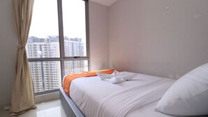 A hotel room with a bed, a window with curtains, and a view of high-rise buildings. - Apatel The Mansion Tower Capilano (Jakarta)