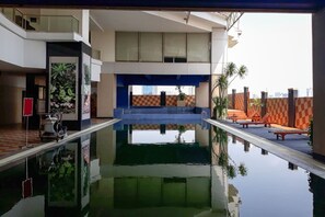 A modern indoor pool with a clear view of the cityscape through the windows.