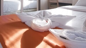 Hotelkamer met een bed, een kledingkast, een airconditioning en een raam met gordijnen.