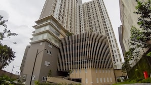 A modern high-rise building with a unique angular design, featuring multiple balconies and a mix of glass and concrete materials.