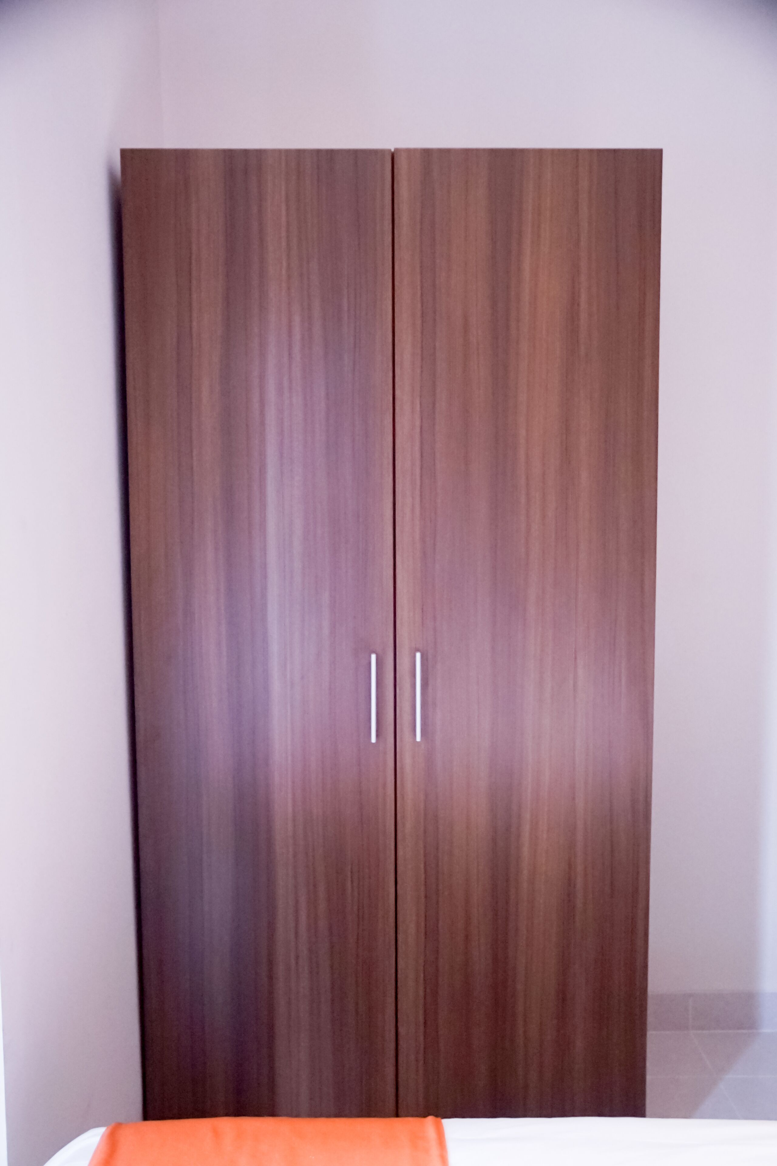 A wardrobe with two doors and silver handles.