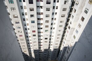 Ein Hochhaus mit zahlreichen Stockwerken, jedes mit vielen Fenstern und Balkonen.