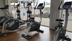 A gym with multiple stationary bikes and a treadmill. - Apatel Silkwood Residences Alam Sutra (Tangerang)