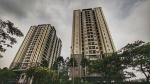 Two high-rise residential buildings with balconies, surrounded by trees and a clear sky. - Apatel Silkwood Residences Alam Sutra (Tangerang)