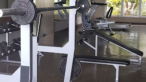 A gym with weightlifting equipment, large windows, and a wooden floor. - Apatel The OAK Tower Pulo Gadung (Jakarta)