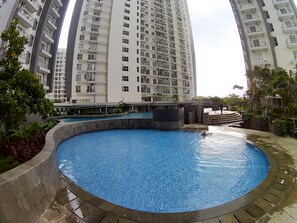 A residential building with multiple balconies and a swimming pool area.