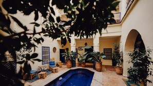 A courtyard with a swimming pool, potted plants, and outdoor seating. - Hotel Sherazade (Marrakech)