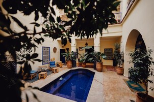 Una piscina al aire libre, sillones reclinables de piscina