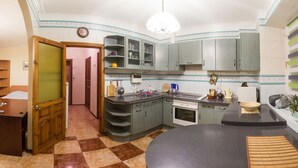 Una cuina compacta amb una illa central, armaris integrats i una zona de menjador.
