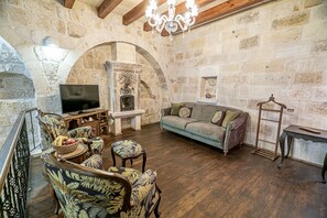 Duplex Cave Suite | Living area | 43-inch Smart TV with satellite channels, TV, fireplace - Zeydem Suites (Ürgüp)