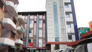A multi-story building with a restaurant on the ground floor, featuring a modern facade with vertical lines and a mix of brick and glass materials. - RamKripa Inn (Karwi)
