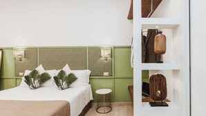 A hotel room with a bed, a small round table, and a shelf with decorative items. - Modern & Elegant Suite in the heart of Sorrento (Sorrento)