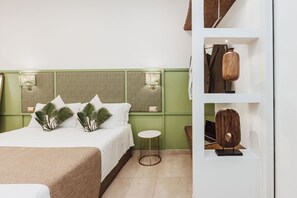 A hotel room with a bed, a small round table, and a shelf with decorative items.