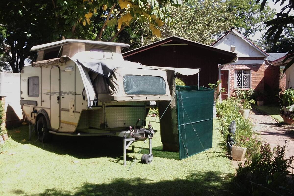 Ein Wohnmobil steht auf einem Grundstück, im Hintergrund ist ein Haus zu sehen.