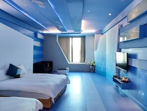 A modern hotel room with a large bed, a TV, and a small seating area. - San Jo Hostel (Kaohsiung)