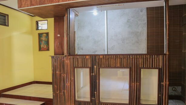 A room with a wooden partition, a tiled floor, and a framed picture on the wall.