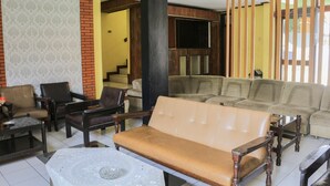 A spacious living area with a sofa set, armchairs, and a coffee table.