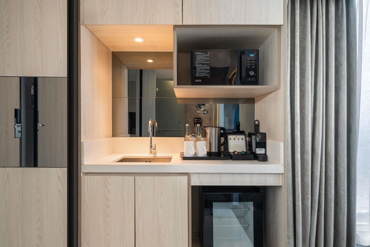 A compact kitchenette with a built-in microwave, coffee maker, and a small refrigerator.