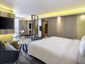 Une chambre d’hôtel avec un grand lit, une télévision, un bureau et une chaise.
