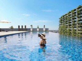 Une piscine à l’eau d’un bleu cristallin, entourée d’une architecture moderne et d’une végétation luxuriante.