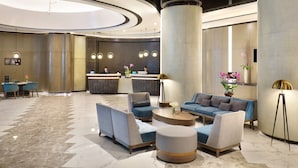 Eine moderne Lobby mit Empfangstresen, einer Sitzecke und einer großen Säule.