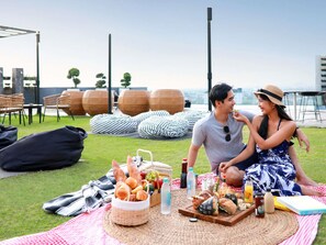 Een buiten eethoek met een picknickopstelling, inclusief eten, drinken en zitplaatsen.