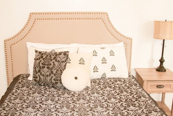 A bed with a patterned bedspread and a headboard with a decorative design.