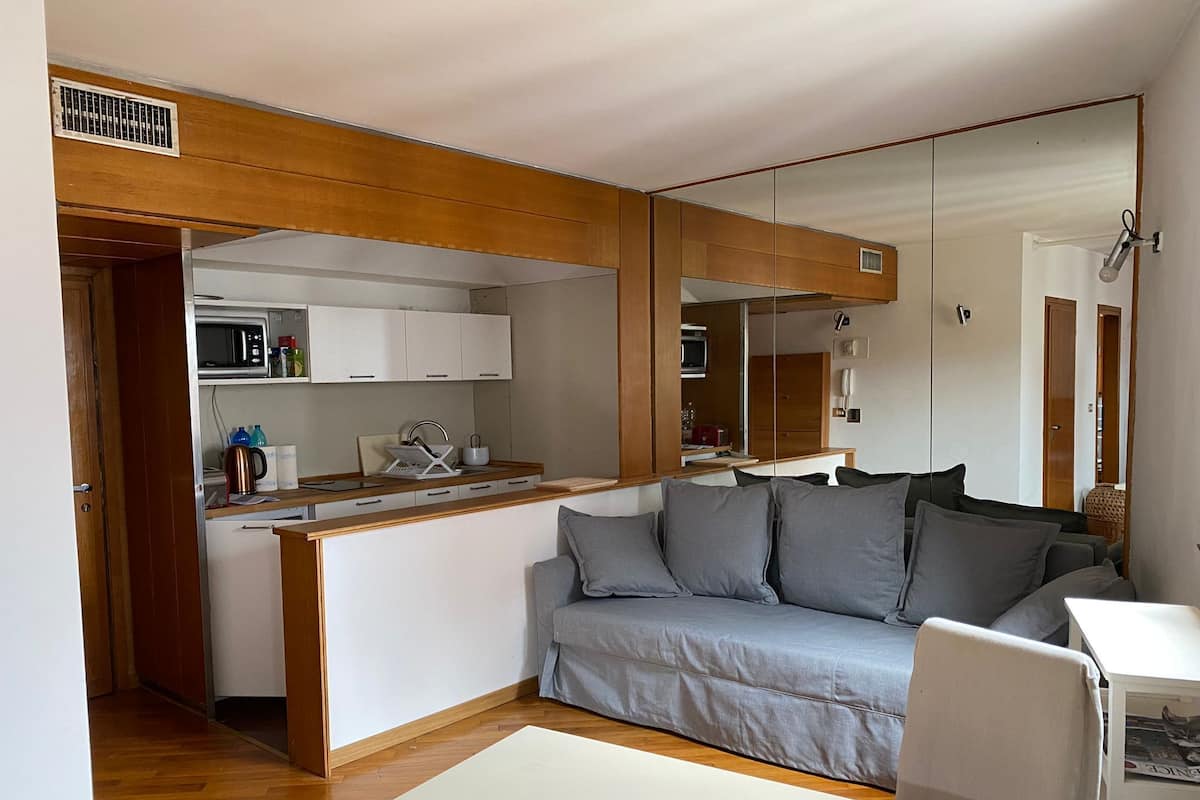 Un espacio habitable funcional con kitchenette, un sofá y comedor.