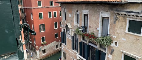 A narrow canal with a gondola, surrounded by historic buildings with balconies and windows.