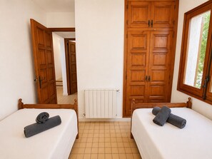 A hotel room with two beds, wooden wardrobes, a radiator, and a window with a view. - Spectacular views of the Mediterranean Sea with a pool! (Palafrugell)
