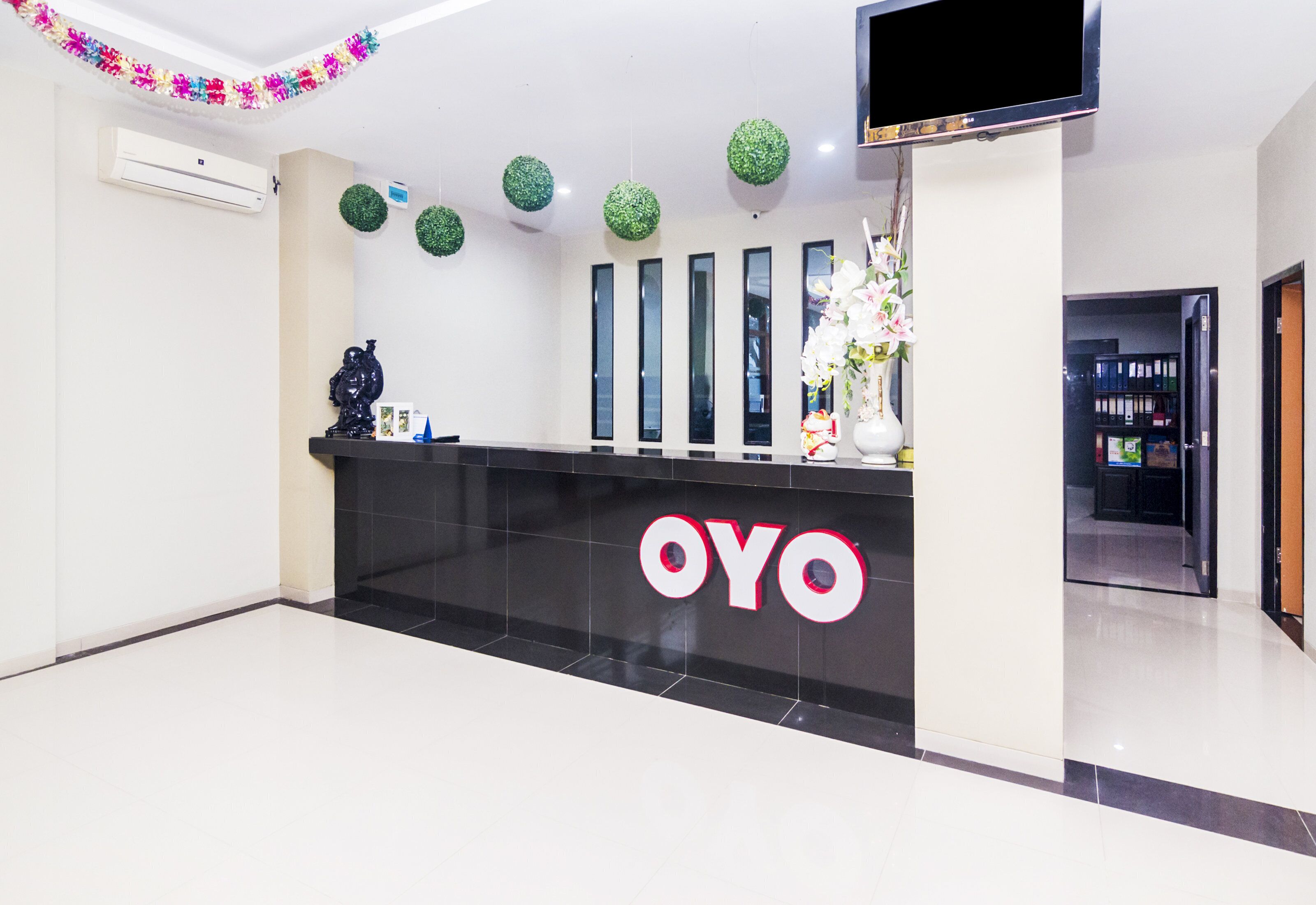 A reception desk with a black counter and the logo 'OYO' in white letters.
