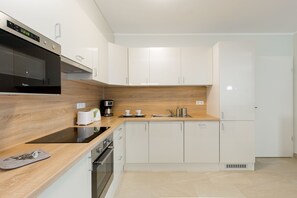 Apartamento superluxo, 2 quartos | Cozinha privada | Geladeira grande, micro-ondas, fogão, cooktop