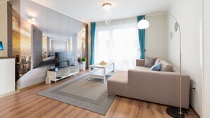 A modern living room with a sofa, TV, and a coffee table. - Budapest Downtown Residence (Budapest)
