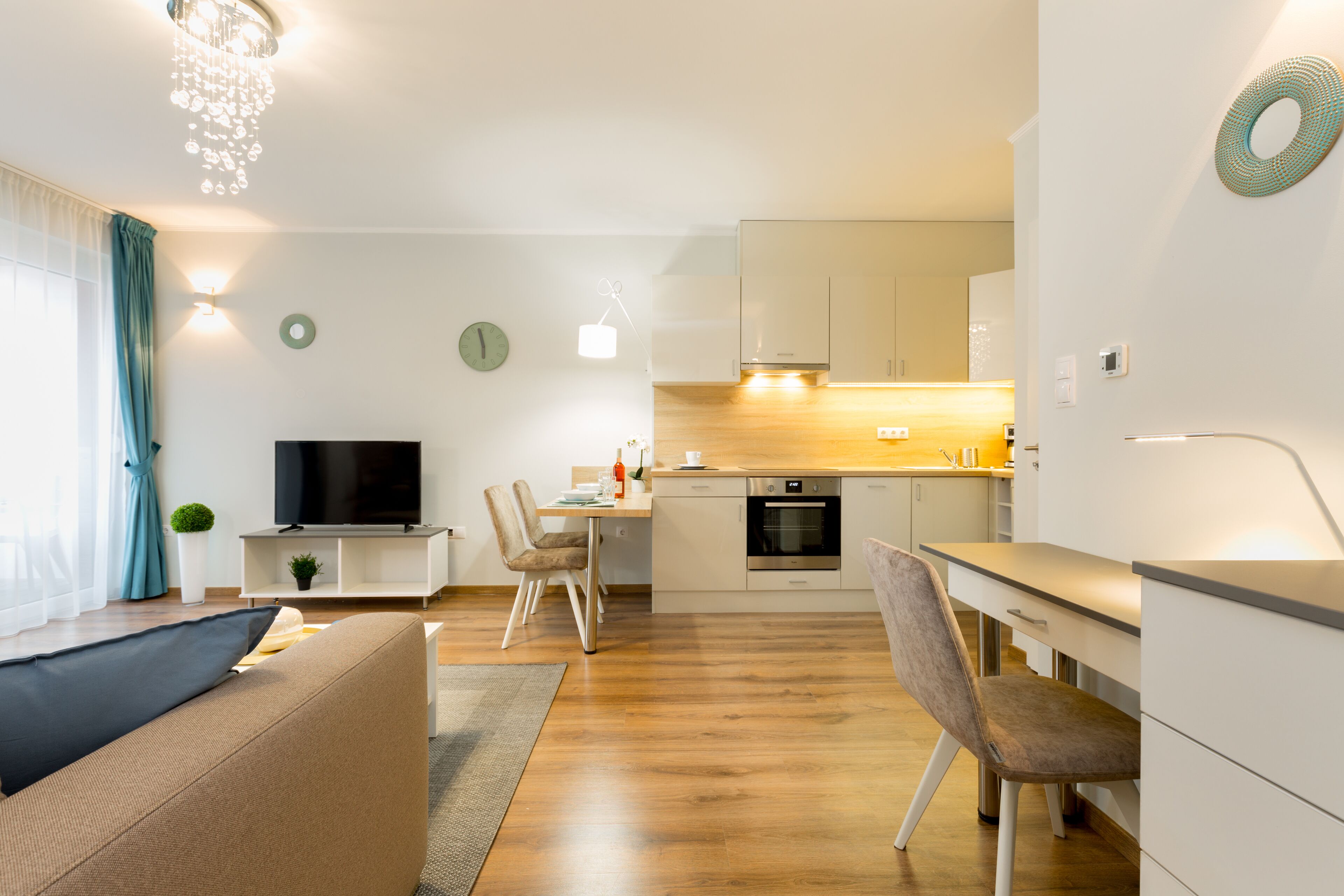 A modern living room with a sofa, TV, and dining area.