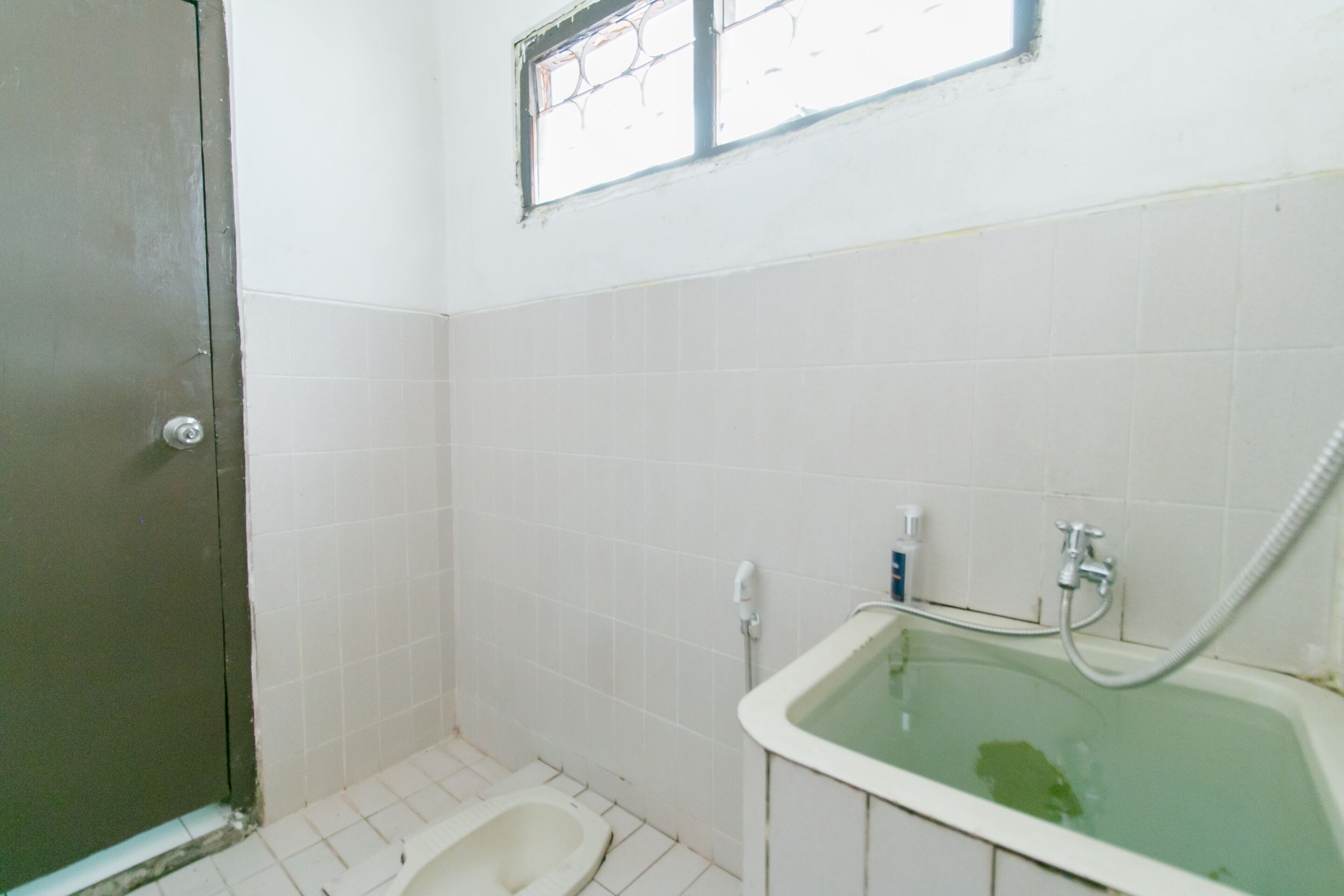 Un baño pequeño y sencillo, con inodoro, lavamanos y bañera.