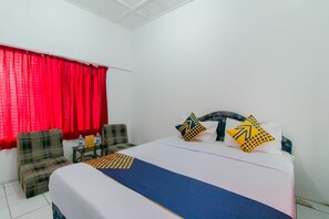 Ein Hotelzimmer mit einem Bett, einer Couch, einem kleinen Tisch und einem roten Vorhang.