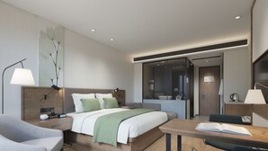 A modern hotel room with a bed, bedside table, lamp, and a desk with a chair. - GreenTree Inn Nanchang Honggutan New Area Cuiyuan Road Subway Station Business Hotel (Nanchang)