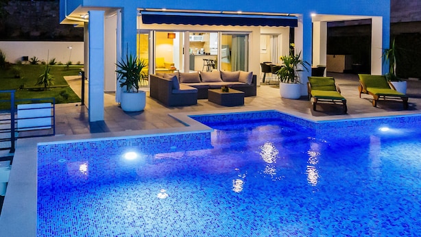 A modern two-story house with a swimming pool, outdoor seating, and a well-lit interior. - Villa Blue Wave , 8 bedrooms, 8 bathrooms,  2 swimming Pool, amazing Sea view  (Kaštel Stari)
