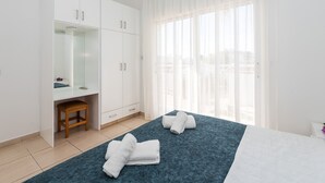 A bedroom with a bed, a desk, and a wardrobe. - Fig Tree Z Holiday Villas DPS02- Two Bed Townhouse (Protaras)