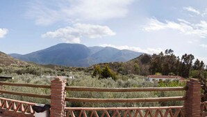 Un paysage montagneux avec une clôture en bois au premier plan.