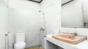 A bathroom with a toilet, shower, and sink.