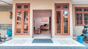 A hotel entrance with a reception desk, a blue motorcycle, and a blue barrel. - OYO 1990 Kost Kuningan Executive Boading House Setiabudi (Jakarta)