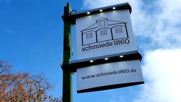 A sign with the text 'schmiede 1860' and a website address 'www.schmiede1860.de'.