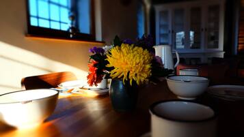 Una mesa de comedor con un jarrón de flores, cuencos y una jofaina.