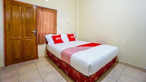 A bedroom with a bed, a wooden wardrobe, and a curtain. - OYO 1720 A2b Residence (Manado)