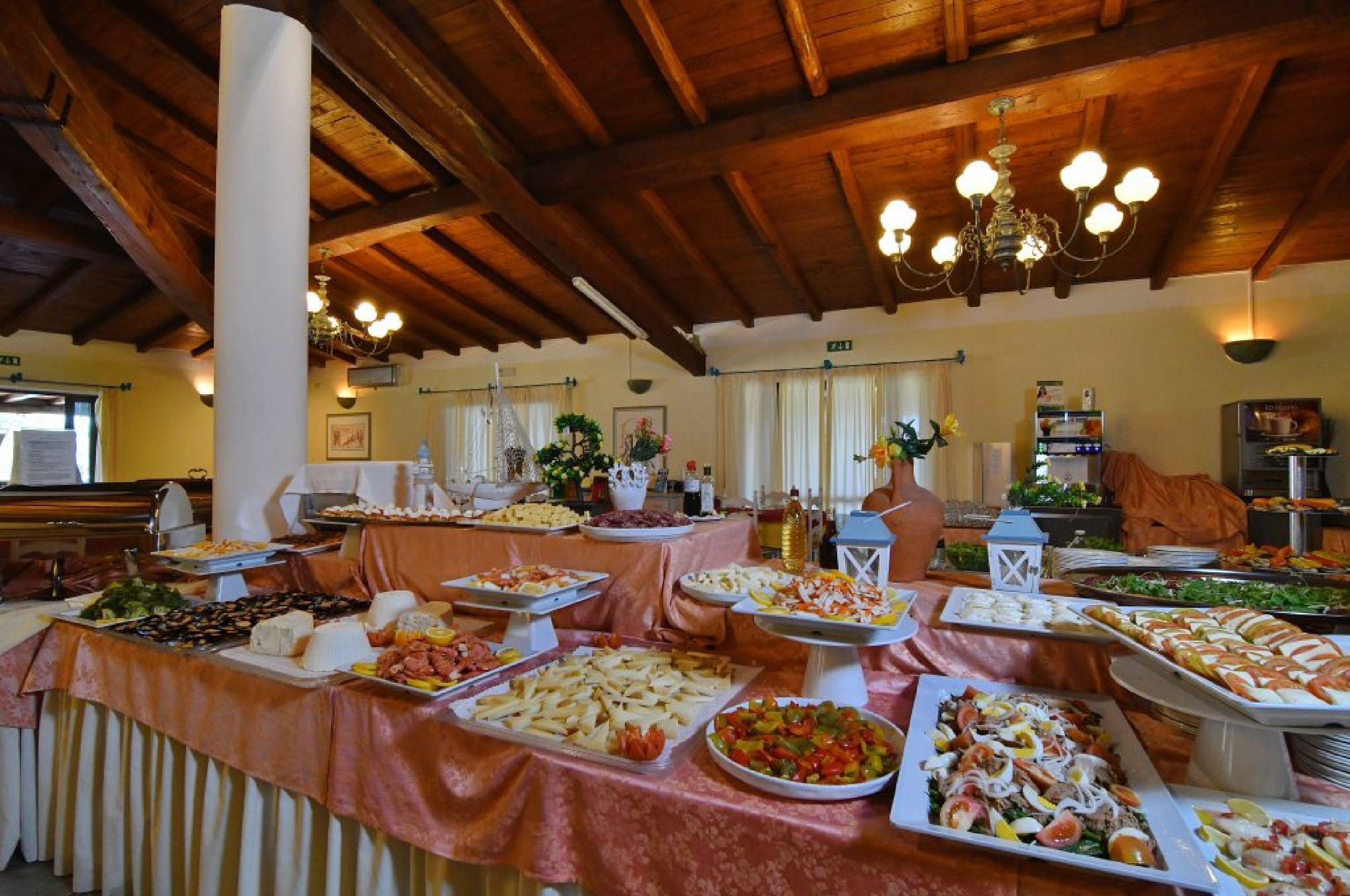 Un buffet proposant une variété de plats, un lustre et un plafond en bois.